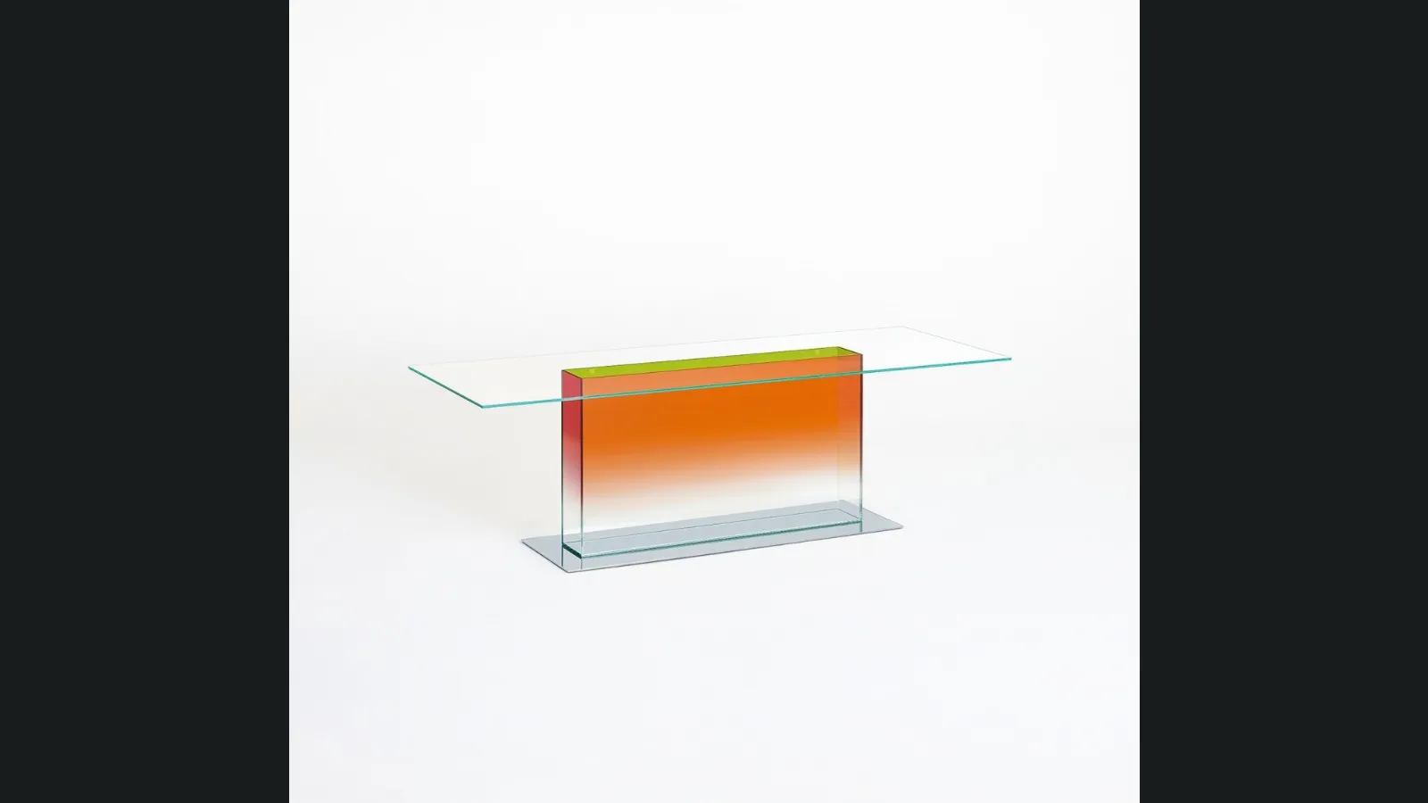 Tavolo rettangolare Donald con top in cristallo e base in acciaio sormontata da un volume in cristallo trasparente colorato di Glas Italia