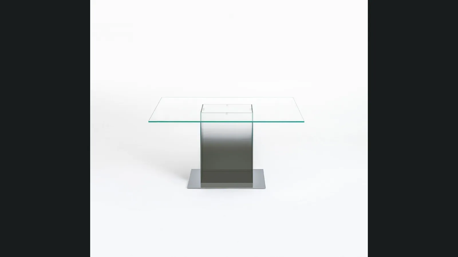 Tavolo quadrato Donald con top in cristallo e base in acciaio sormontata da un volume in cristallo trasparente colorato di Glas Italia